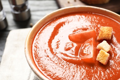 Bowl with fresh homemade tomato soup on table, closeup