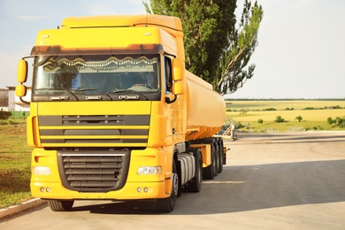 Photo of Modern yellow truck on country road. Space for text