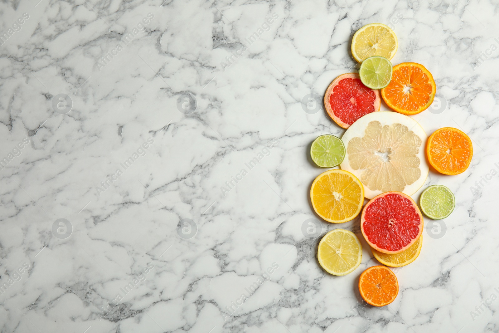 Photo of Different citrus fruits on marble background, top view. Space for text