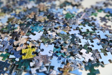 Photo of Jigsaw puzzle pieces on table, closeup view