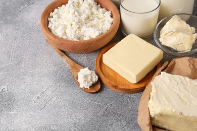 Photo of Tasty homemade butter and dairy products on grey table. Space for text