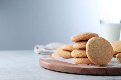 Many tasty sugar cookies on light grey table, space for text