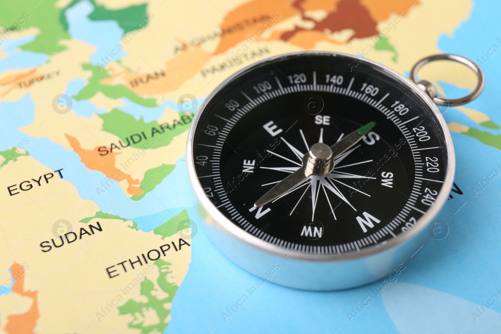Photo of One compass on world map, space for text. Tourist equipment