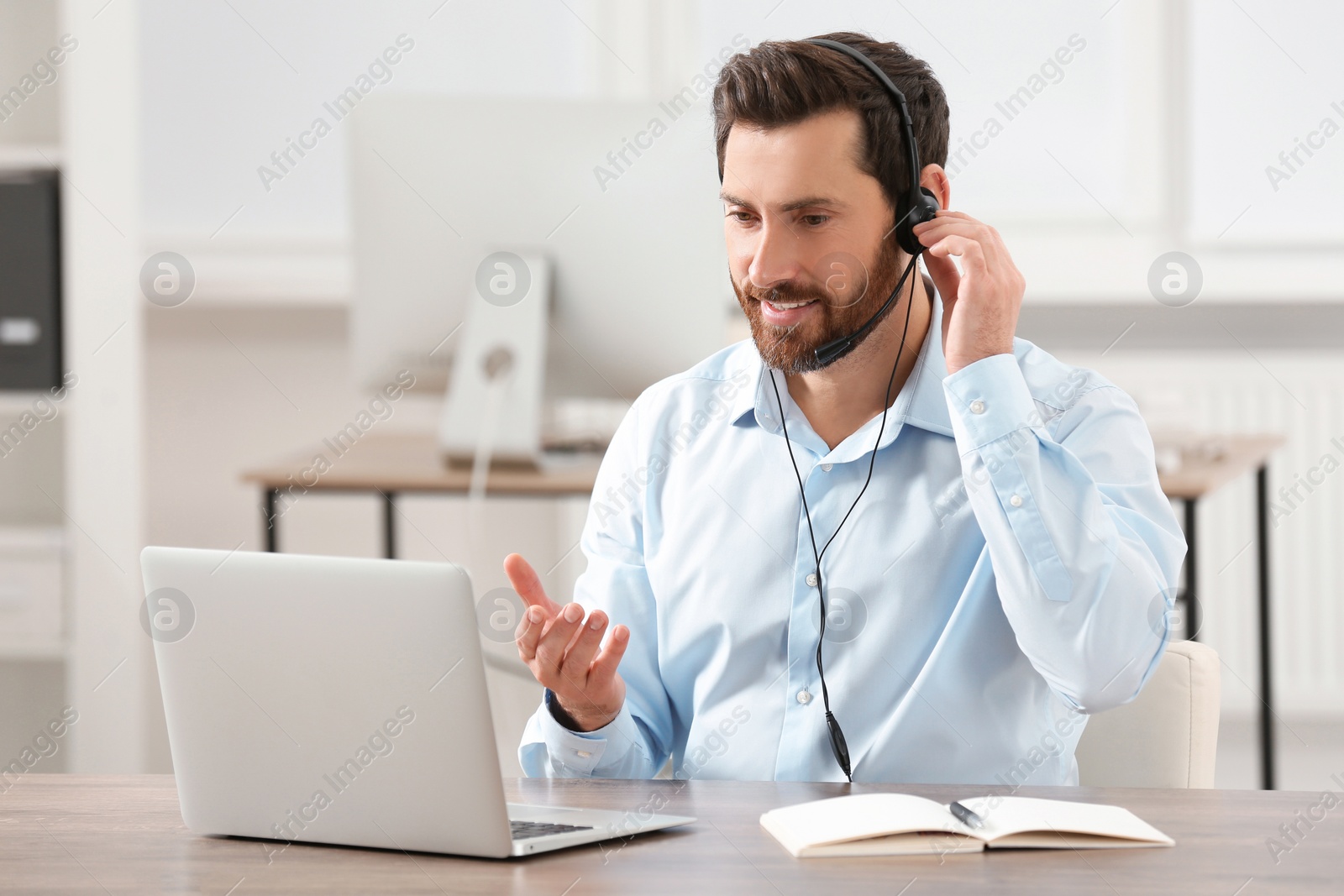 Photo of Hotline operator with headset working in office