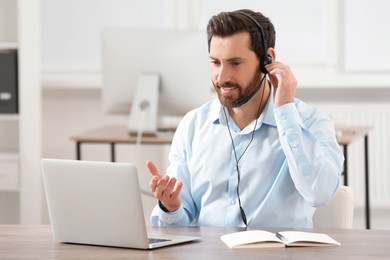 Hotline operator with headset working in office