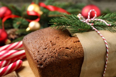 Photo of Delicious gingerbread cake with fir twigs on table, closeup