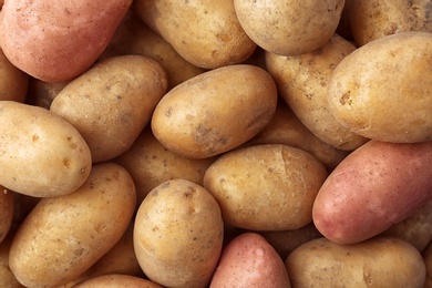 Photo of Fresh ripe organic potatoes as background, top view