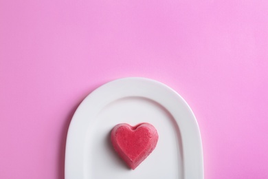 Photo of Plate with heart shaped berry ice cube on color background, top view. Space for text