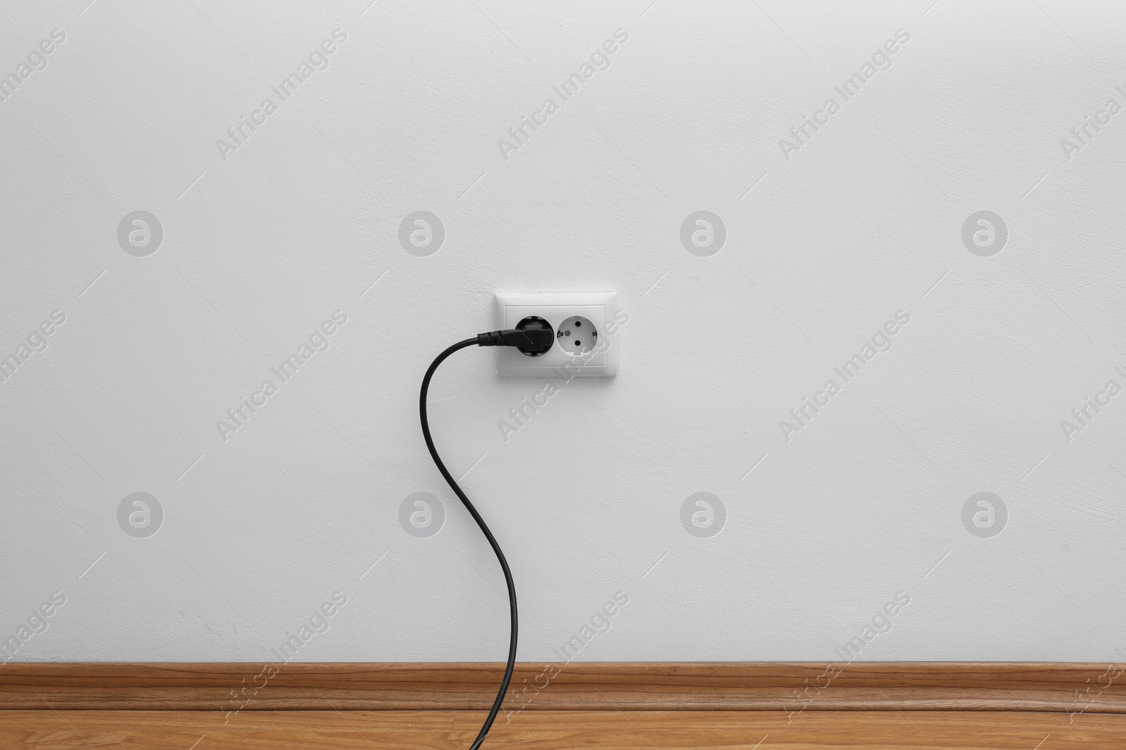 Photo of Power socket and plug on wall indoors. Electrician's equipment