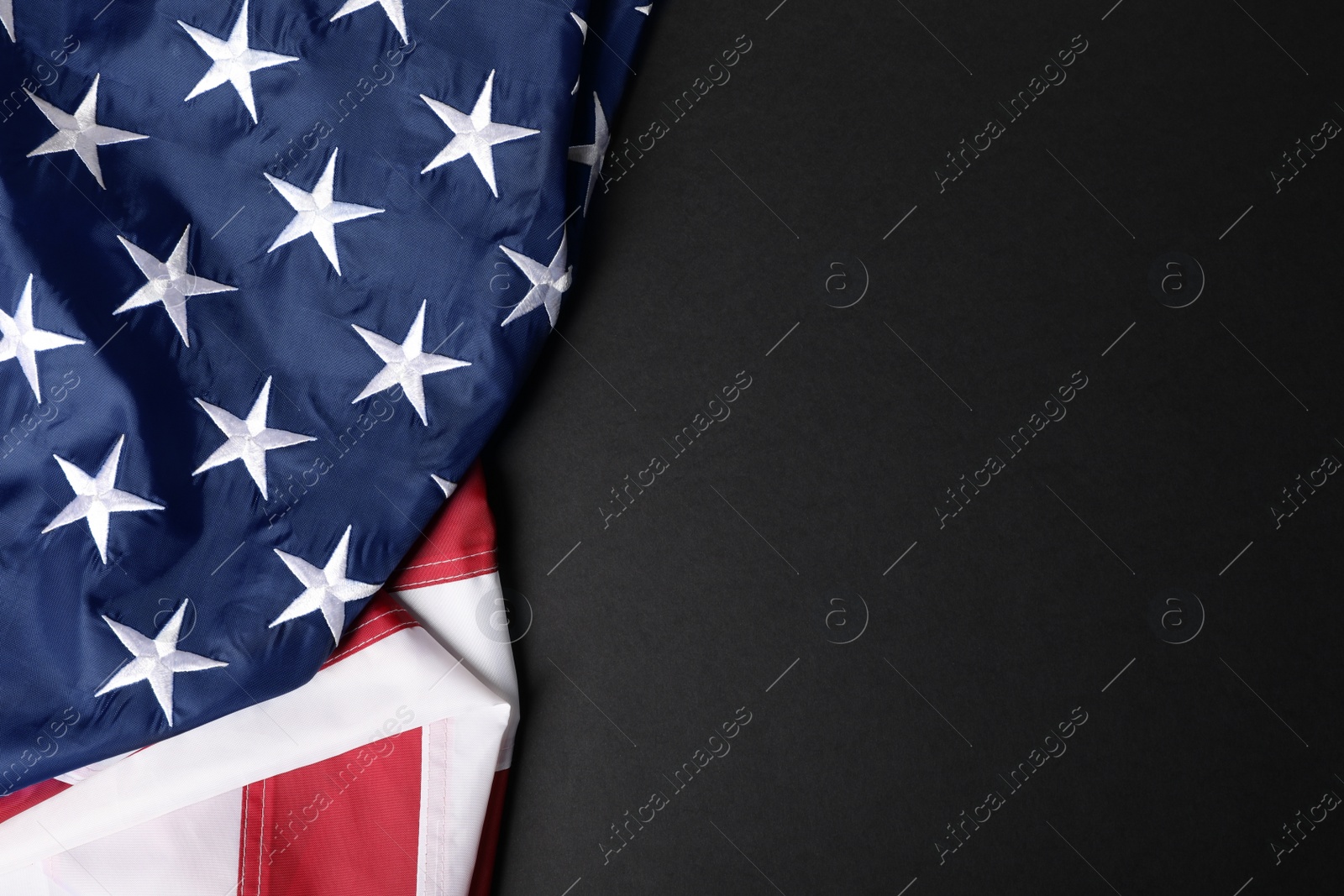 Photo of USA flag on black background, top view. Space for text