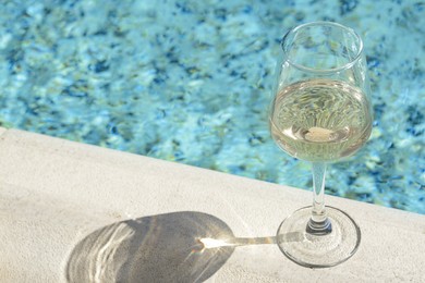 Photo of Glasstasty wine on swimming pool edge, space for text