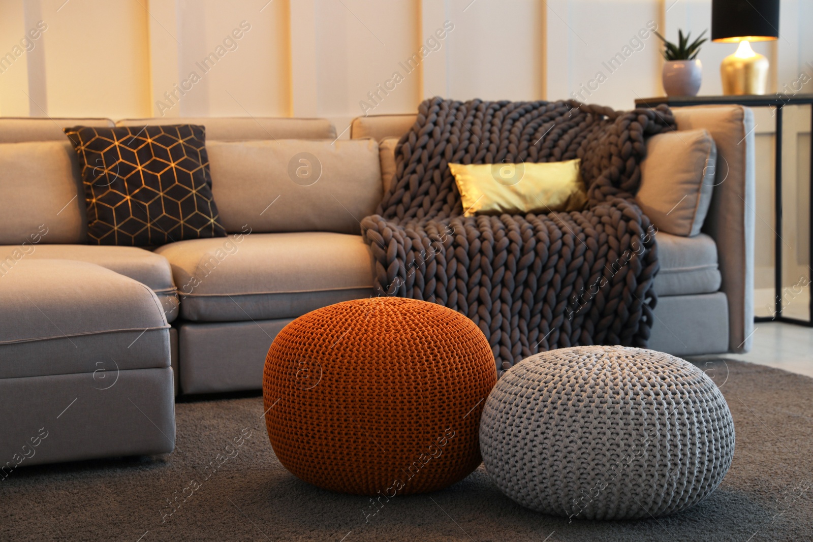 Photo of Living room interior with different stylish knitted poufs and sofa