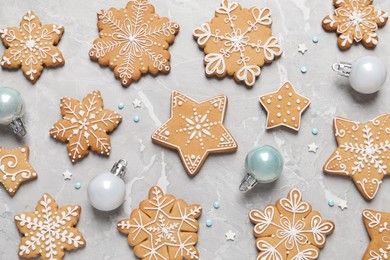 Photo of Tasty Christmas cookies and baubles on light grey marble table, flat lay