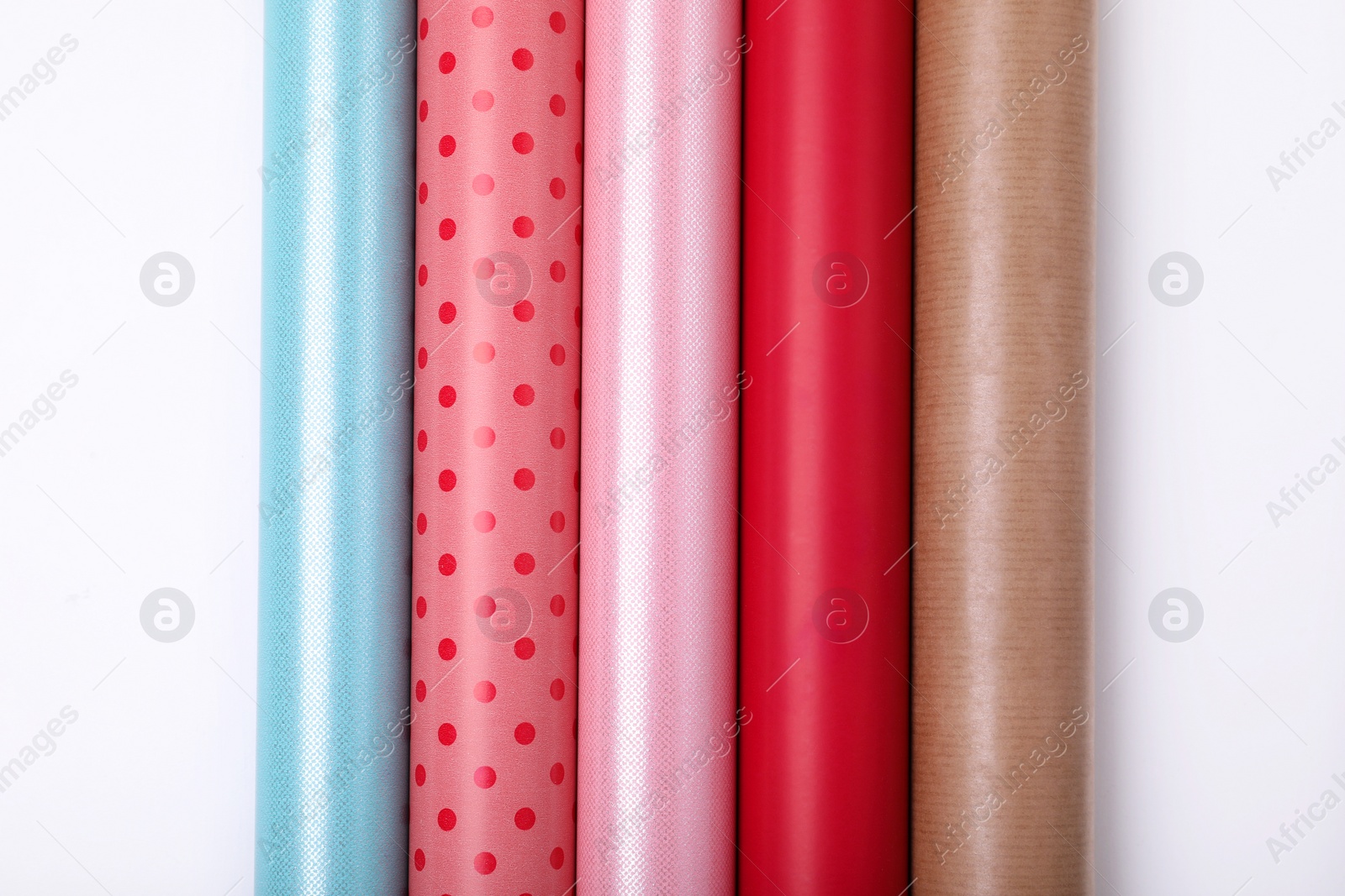 Photo of Rolls of different bright wrapping paper on white background, top view