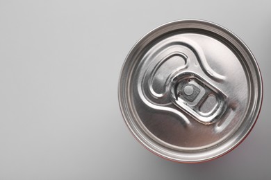 Energy drink in can on grey background, top view. Space for text