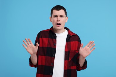 Photo of Portrait of surprised man on light blue background