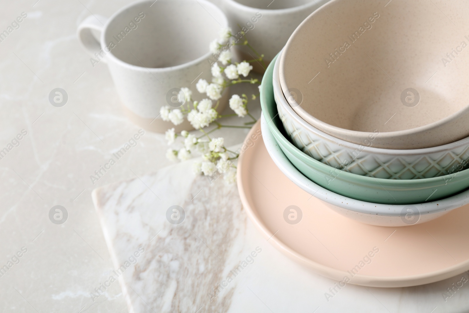 Photo of Different dishware and marble board on table, space for text