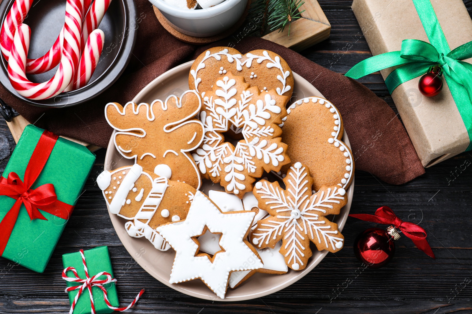 Photo of Delicious Christmas cookies on black wooden table table, flat lay