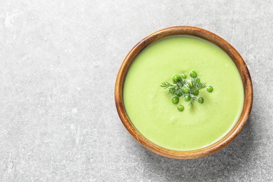 Fresh vegetable detox soup made of green peas in dish on table, top view with space for text