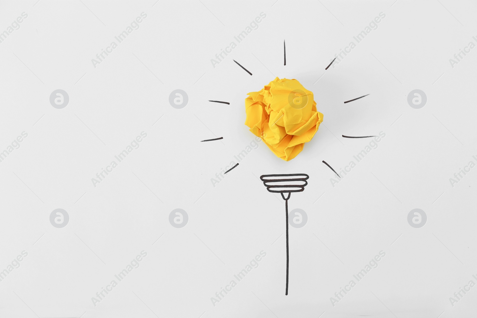 Photo of Composition with crumpled paper ball, drawing of lamp bulb and space for text on white background, top view. Creative concept