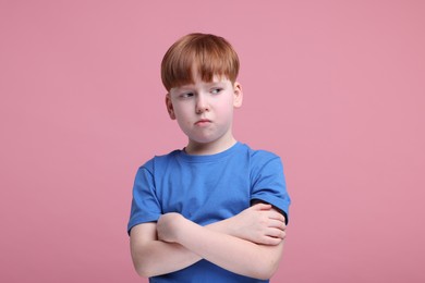 Photo of Portrait of sad little boy on pink background