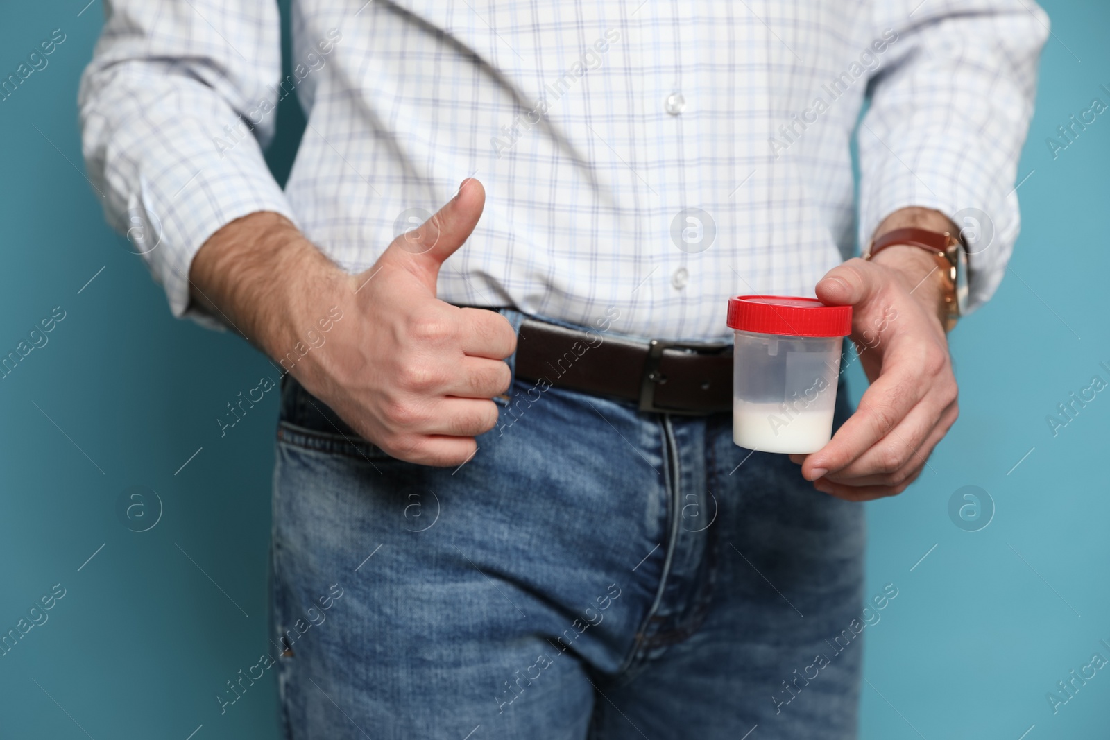 Photo of Donor holding container with sperm on turquoise background, closeup