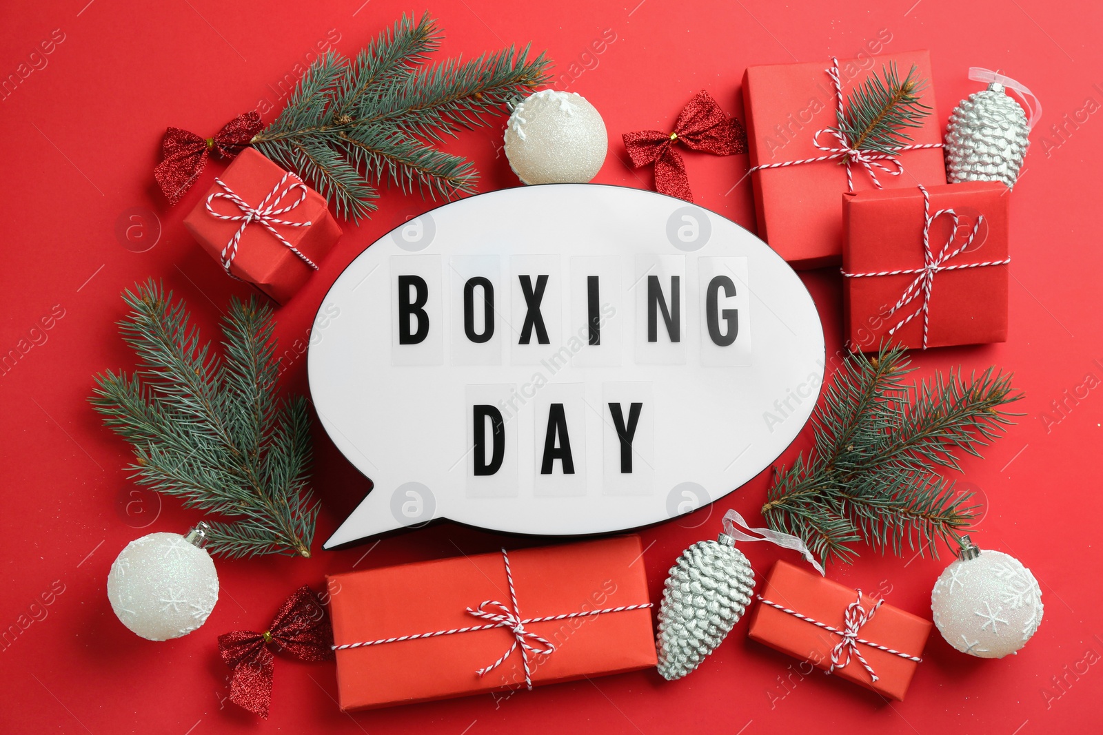 Photo of Speech bubble with phrase BOXING DAY and Christmas decorations on red background, flat lay