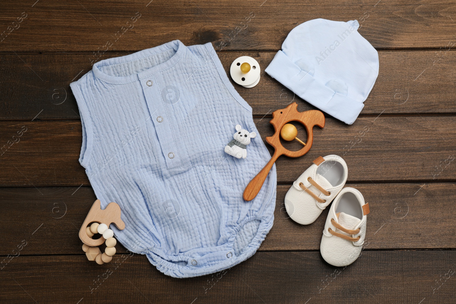 Photo of Flat lay composition with baby clothes and accessories on wooden table