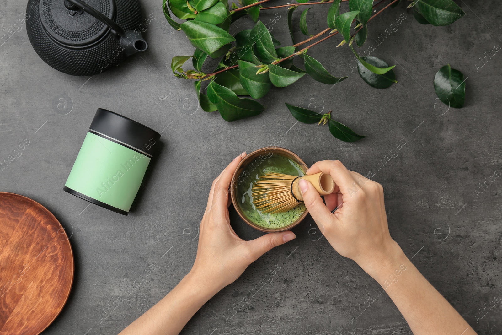 Photo of Woman preparing matcha tea at table, top view