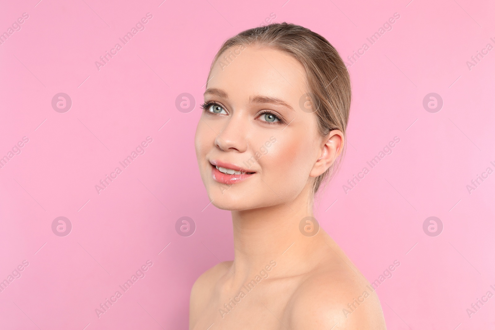 Photo of Portrait of young woman with beautiful face on pink background