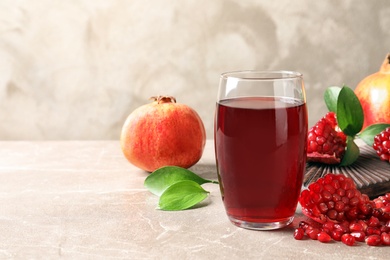 Composition with glass of fresh pomegranate juice on table. Space for text