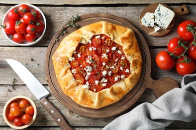 Photo of Flat lay composition of tasty galette with tomato, thyme and cheese (Caprese galette) on wooden table