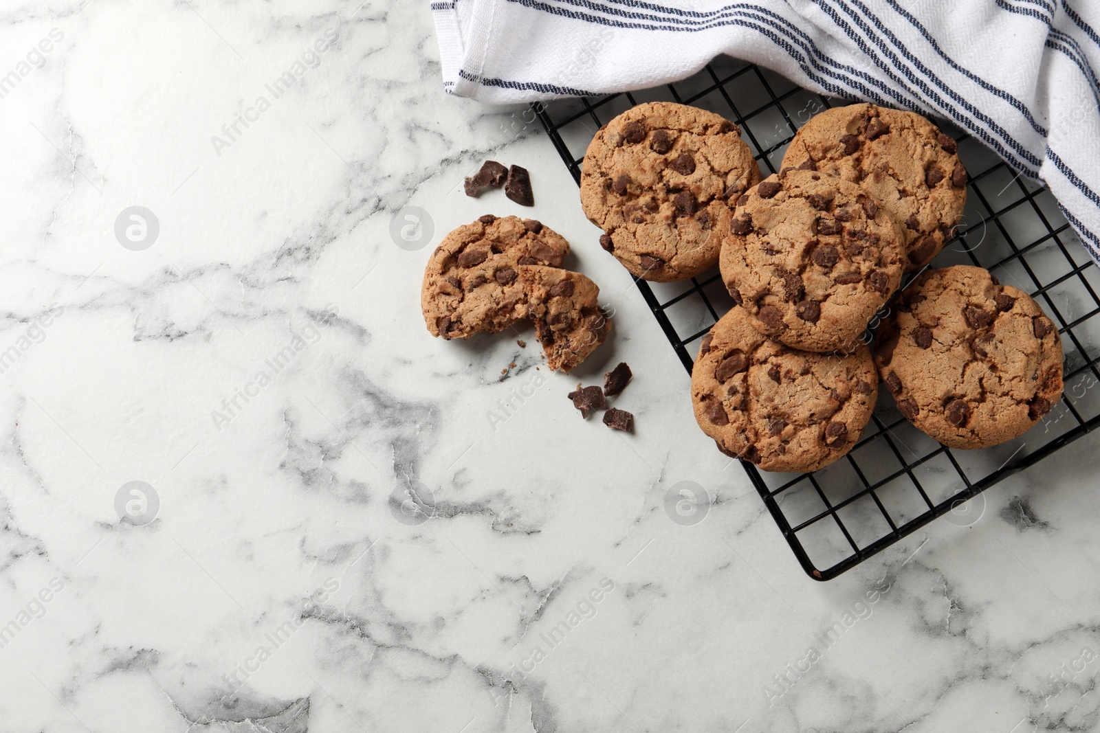 Photo of Delicious chocolate chip cookies on white marble table, flat lay. Space for text