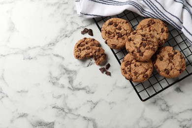 Photo of Delicious chocolate chip cookies on white marble table, flat lay. Space for text