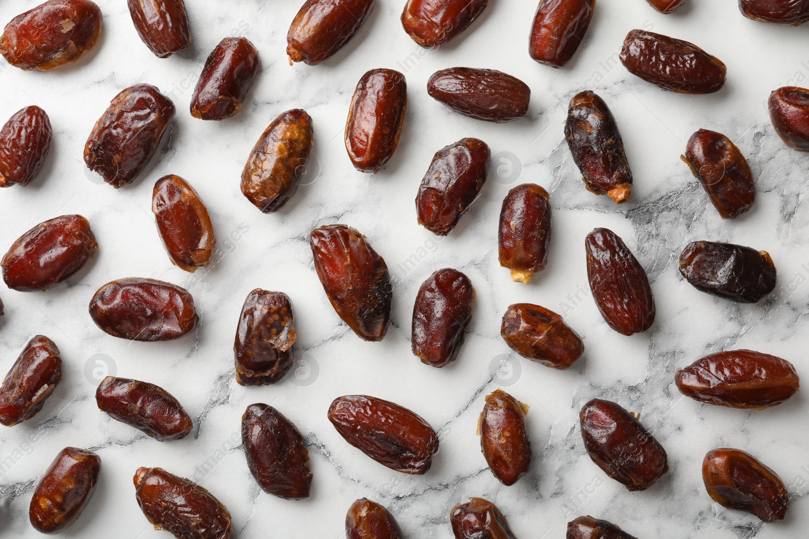 Photo of Flat lay composition with dates on marble background. Dried fruit as healthy snack