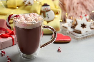 Composition with delicious marshmallow drink, festive items and yellow sweater on light table