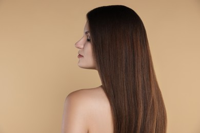 Photo of Young woman with strong healthy hair on beige background