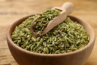 Photo of Bowl and scoop with fennel seeds on table, closeup