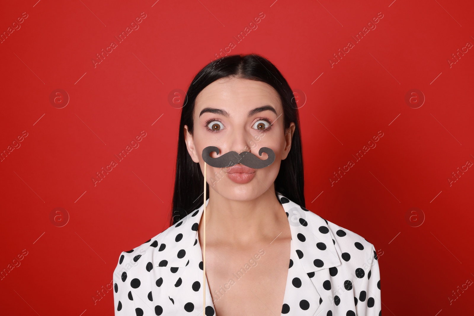 Photo of Funny woman with fake mustache on red background