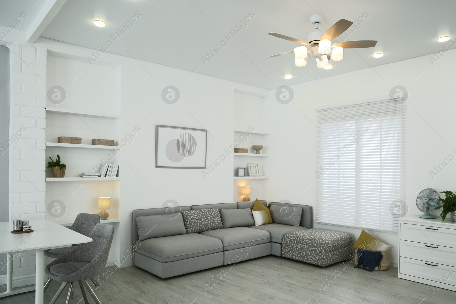 Photo of Comfortable furniture, ceiling fan and accessories in stylish living room