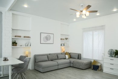 Comfortable furniture, ceiling fan and accessories in stylish living room