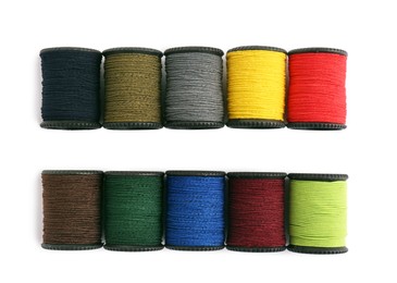 Photo of Set of colorful sewing threads on white background, top view