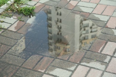 Puddle after rain on street tiles outdoors