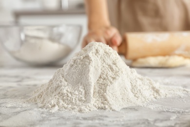 Pile of flour and woman on background