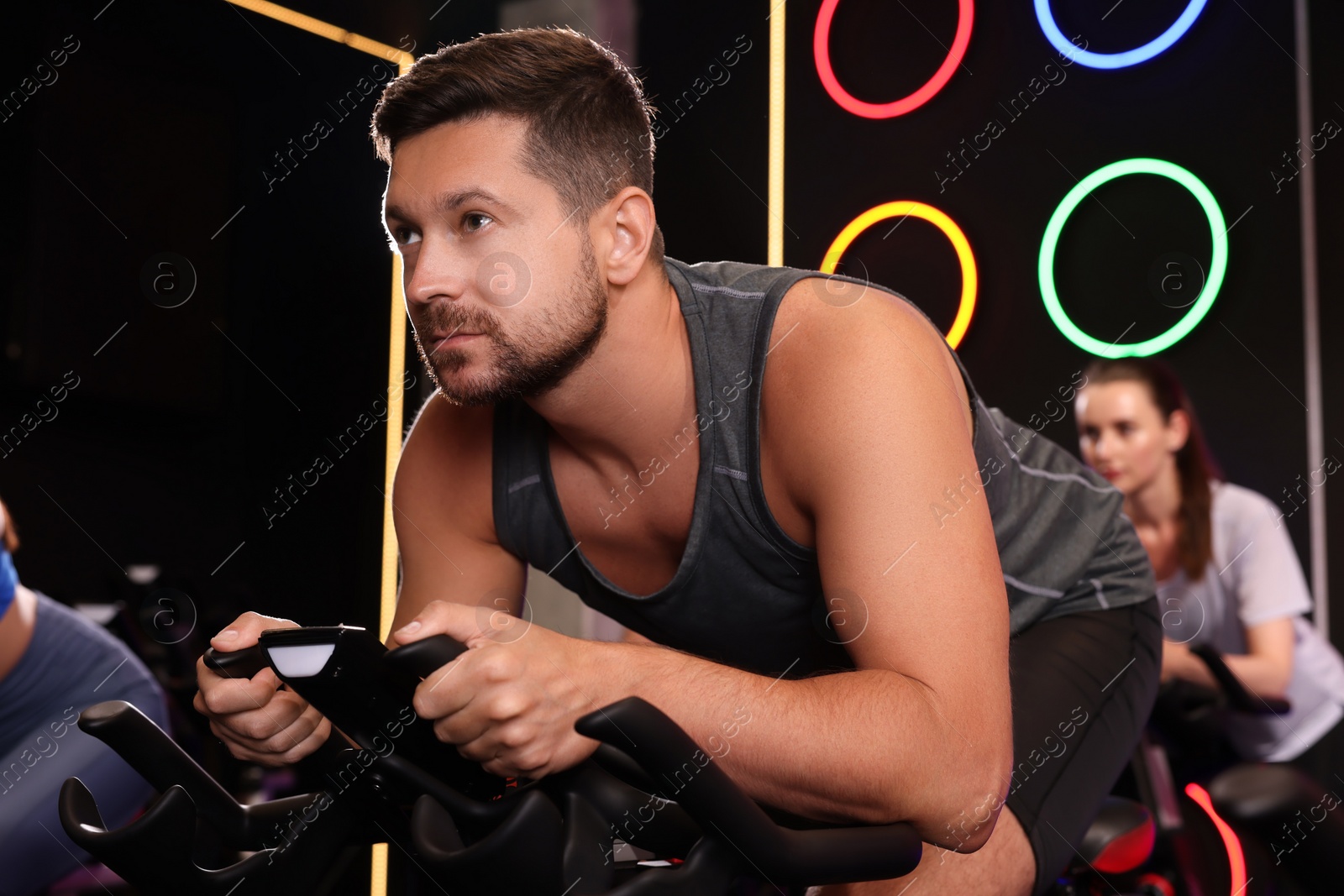 Photo of Group of people training on exercise bikes in fitness club