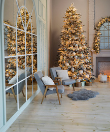 Festive room interior with stylish furniture and beautiful Christmas tree
