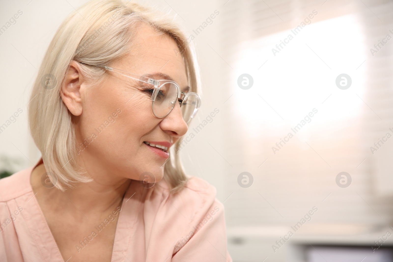 Photo of Beautiful mature woman in glasses at home. Space for text