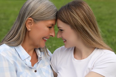 Happy mature mother and her daughter outdoors