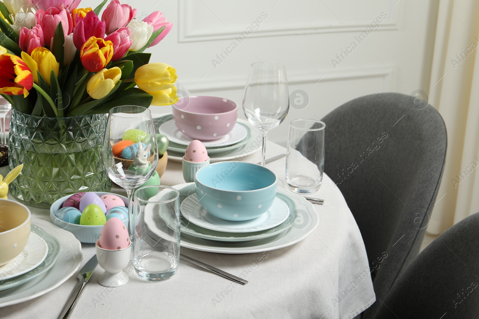 Photo of Easter celebration. Festive table setting with beautiful flowers and painted eggs