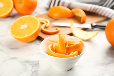 Photo of Orange fruit peels on white marble table